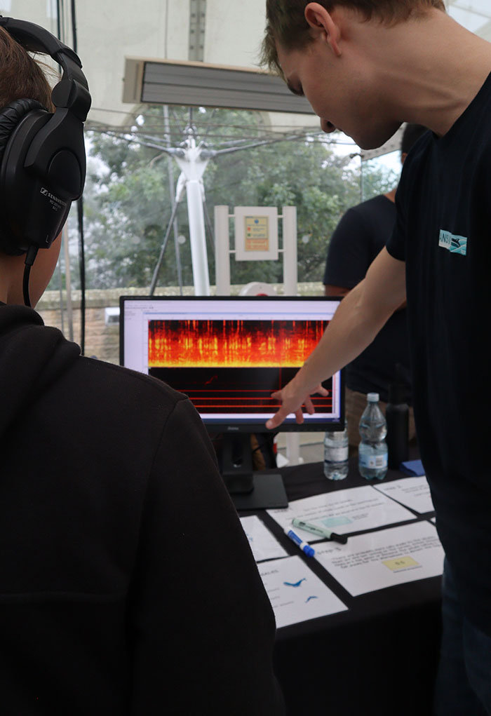 Researcher talking about a spectrograph with a visitor