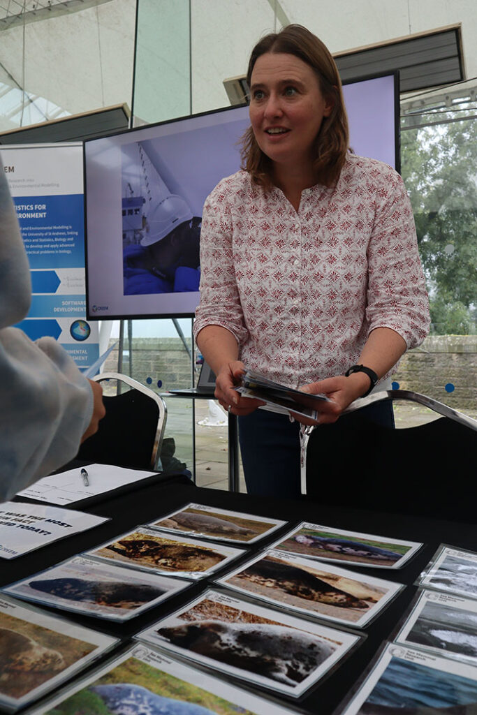 Researcher speaking with visitors with photographs on the table in front of them