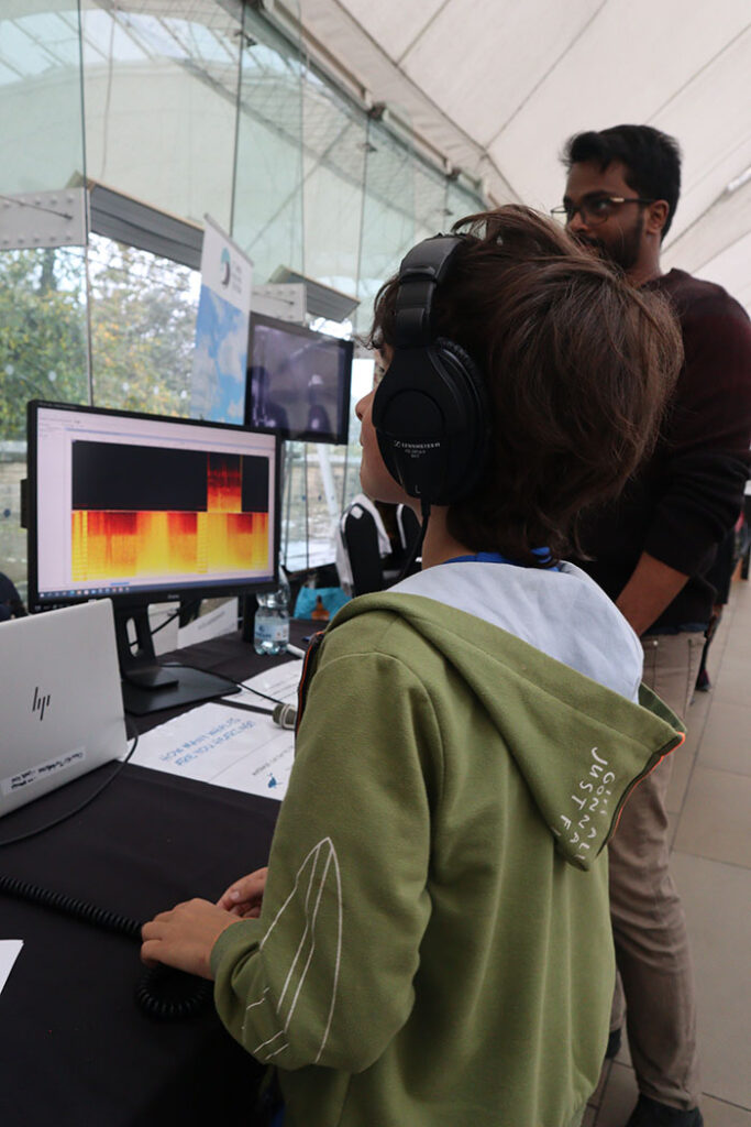 Child looking at computer screen displaying a spectrograph